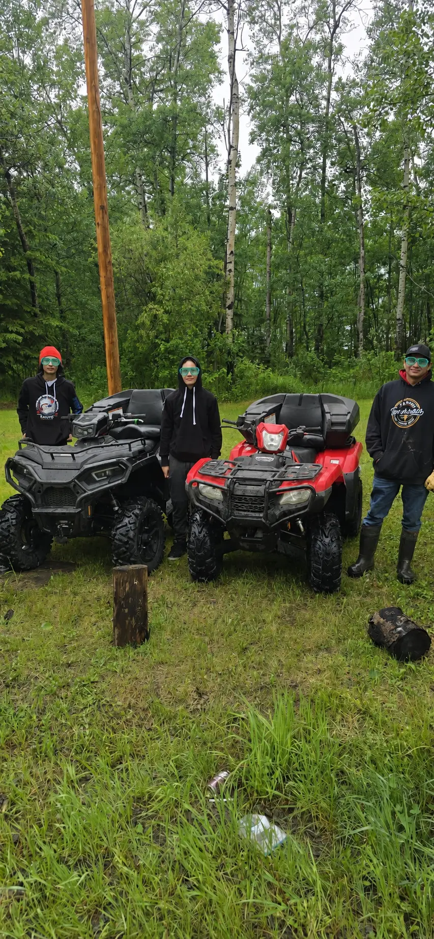 Three customers with two ATVs at the treeline