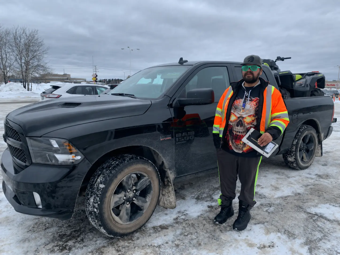 A customer in a work jacket with a black Ram and an ATV in the box
