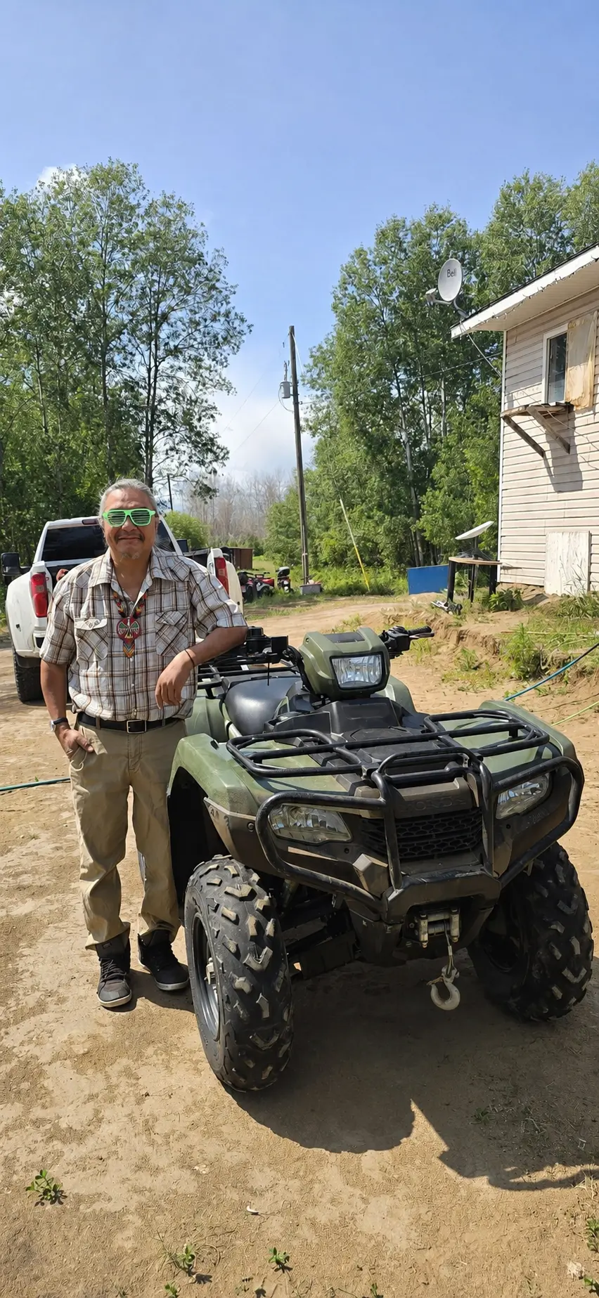 A customer with a green ATV delivered to his yard